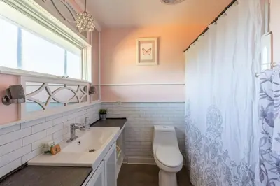 a bathroom with a toilet and a sink and a window at Scenic View Estate with Pool & Hot Tub in San Diego