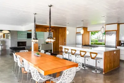 a kitchen with a wooden table and white chairs at Scenic View Estate with Pool & Hot Tub in San Diego