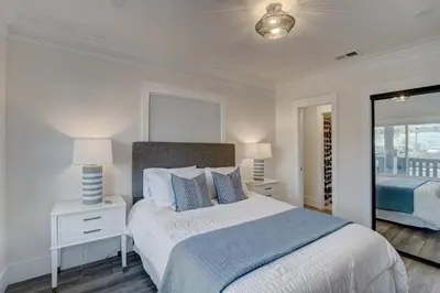 a white bedroom with a bed and a window at Historic Barrio Logan Bungalow in San Diego