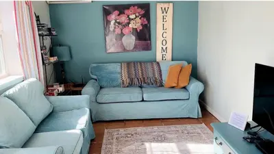 a living room with a blue couch and a chair at Pet Friendly Breathtaking Cottage with Great Views and Hot-tub in Rainbow, California in Fallbrook