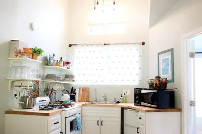a kitchen with white cabinets and a microwave at Pet Friendly Charming Cottage with Incredible Views and Hot-tub in Rainbow, California in Fallbrook