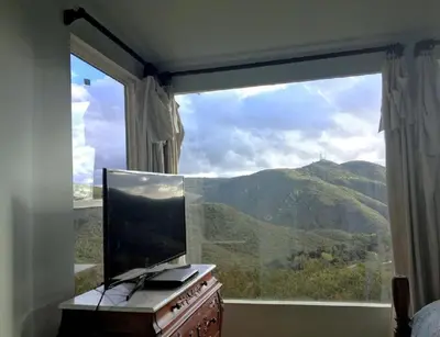 a bedroom with a large window with a view of a mountain at Pet Friendly Charming Cottage with Incredible Views and Hot-tub in Rainbow, California in Fallbrook