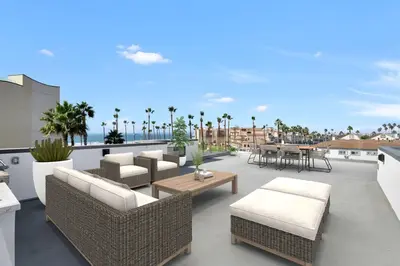 a patio with couches and tables on a roof at Steps to the Beach in Imperial Beach
