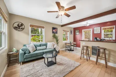 a living room with a green couch and a bar at 1BD Heart of PB Pet Friendly Private Sanctuary in San Diego
