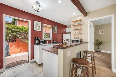 a kitchen with red walls and a counter and stools at 1BD Heart of PB Pet Friendly Private Sanctuary in San Diego