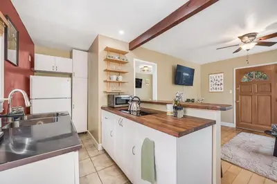 a kitchen with white cabinets and a counter top at 1BD Heart of PB Pet Friendly Private Sanctuary in San Diego