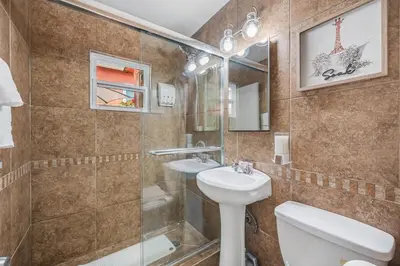 a bathroom with a sink and a toilet and a shower at 1BD Heart of PB Pet Friendly Private Sanctuary in San Diego