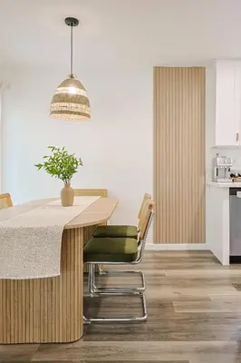 a kitchen with a wooden table with a green chair at Immaculate Home near Balboa Park, SD Zoo, & Cafés in San Diego