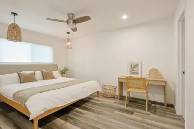 a white bedroom with a bed and a desk at Immaculate Home near Balboa Park, SD Zoo, & Cafés in San Diego