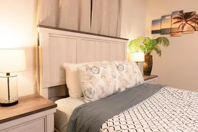 a bedroom with a bed and two lamps and a plant at Central San Diego 3BR Home Near Beaches in San Diego