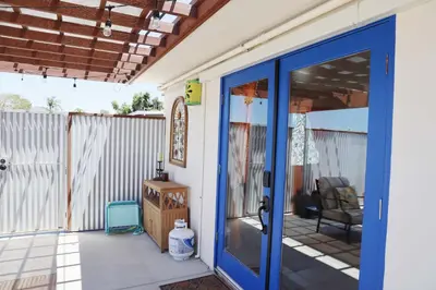 a porch with a blue door and a chair at Colorful Casita Frida 1BD Retreat by Balboa Park in San Diego