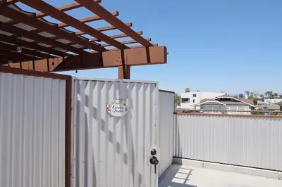 a white fence with a wooden pergola over it at Colorful Casita Frida 1BD Retreat by Balboa Park in San Diego
