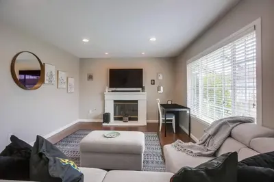 a living room with a couch and a fireplace at 15 Min from Torrey Pines State Beach and Golf in San Diego