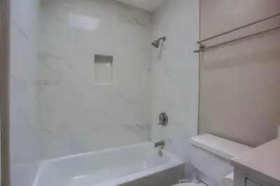 a white bathroom with a shower and a white tub at 15 Min from Torrey Pines State Beach and Golf in San Diego