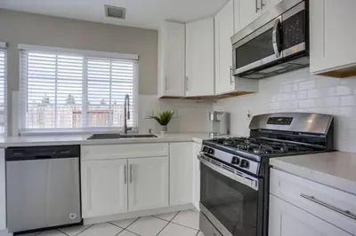 a kitchen with white cabinets and a stove top oven at 15 Min from Torrey Pines State Beach and Golf in San Diego