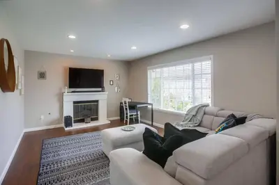 a living room with a couch and a fireplace at 15 Min from Torrey Pines State Beach and Golf in San Diego