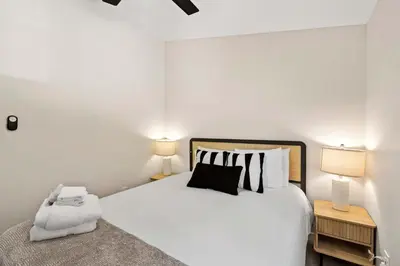 a bedroom with a white bed and two lamps at 15 Min to Beach and Zoo - Hot Tub - Cozy Fire Villa Pit in San Diego