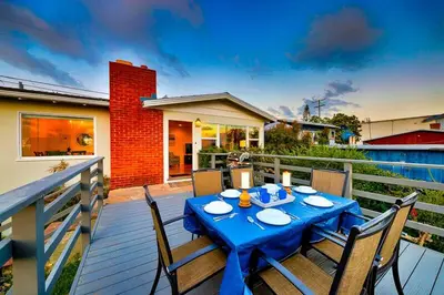 a blue table and chairs on a wooden deck with at Ocean Views Walk to the Beach with King Suite in Encinitas