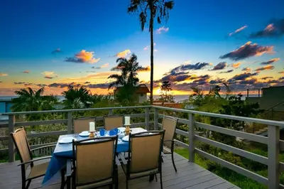 a table and chairs on a deck with a view of the ocean at Ocean Views Walk to the Beach with King Suite in Encinitas