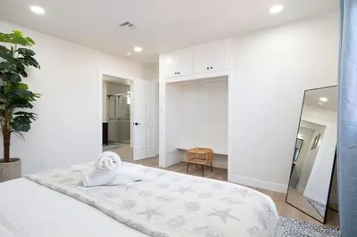 a white bedroom with a bed and a mirror at 4 Miles to Beach Central and Newly Renovated in San Diego