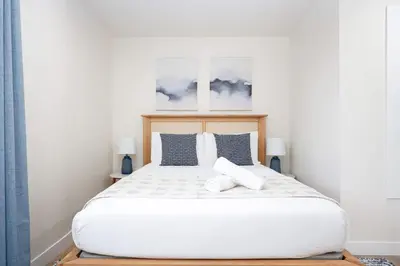 a bedroom with a large white bed with two pillows at 4 Miles to Beach Central and Newly Renovated in San Diego