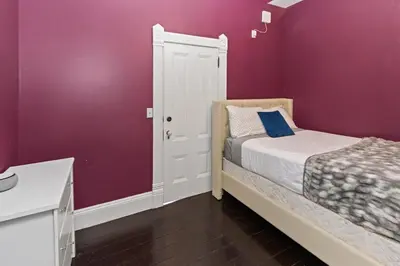 a small bedroom with purple walls and a bed at 1900's Victorian Home Sleeps 22 8BDRM 3Bath in San Diego