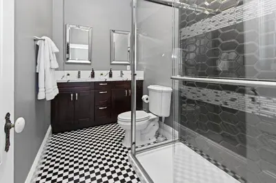 a bathroom with a toilet and a glass shower at 1900's Victorian Home Sleeps 22 8BDRM 3Bath in San Diego