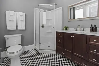 a bathroom with a shower and a toilet and a sink at 1900's Victorian Home Sleeps 22 8BDRM 3Bath in San Diego