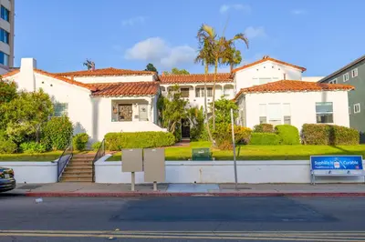 a white house with a palm tree and a street at 2BR Retreat Near Balboa Park in San Diego
