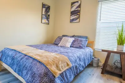 a bedroom with a bed with a blue comforter at 2BR Retreat Near Balboa Park in San Diego