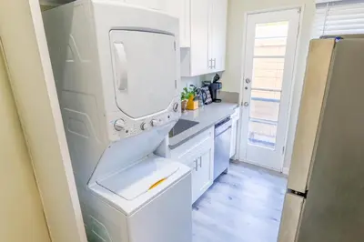 a white kitchen with a sink and a refrigerator at 2BR Retreat Near Balboa Park in San Diego