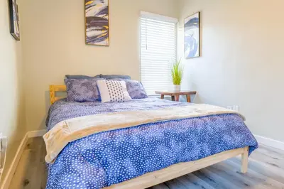a bedroom with a bed with a blue comforter at 2BR Retreat Near Balboa Park in San Diego