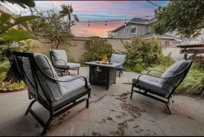 a patio with four chairs and a table with a fire pit at Hilltop Villa Offering Uninterrupted Ocean Vistas in San Diego