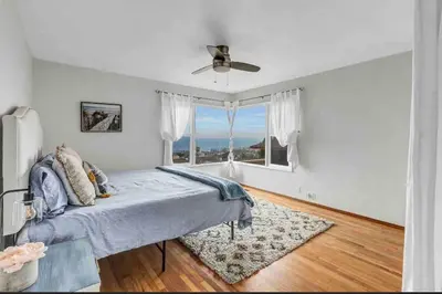a bedroom with a bed and a large window at Hilltop Villa Offering Uninterrupted Ocean Vistas in San Diego