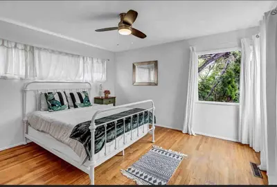 a bedroom with a white bed and a window at Hilltop Villa Offering Uninterrupted Ocean Vistas in San Diego
