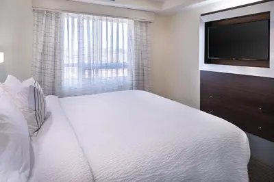 a bedroom with a white bed and a flat screen tv at Residence Inn by Marriott Temecula Murrieta in Murrieta
