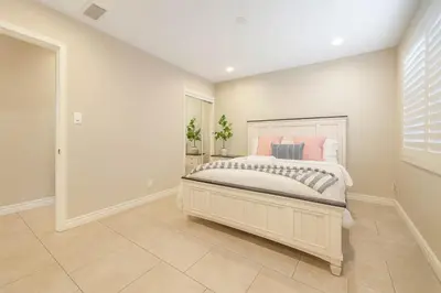 a bedroom with a large bed with pink pillows at 2 Homes in 1 Sleeps 18 10 Min to Zoo and Beach in San Diego