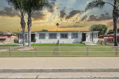 a white house with a fence and palm trees at 2 Homes in 1 Sleeps 18 10 Min to Zoo and Beach in San Diego