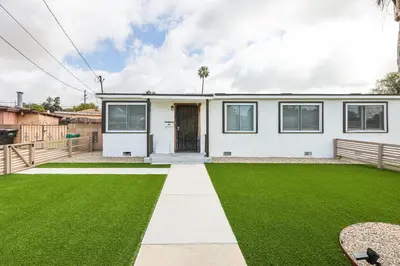 a house with a green lawn in front of it at 2 Homes in 1 Sleeps 18 10 Min to Zoo and Beach in San Diego