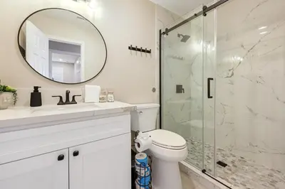 a bathroom with a shower and a toilet and a mirror at 2 Homes in 1 Sleeps 18 10 Min to Zoo and Beach in San Diego