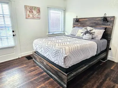 a bedroom with a bed with a wooden headboard at Eagle's Nest - Hot Tub & Stunning Bay View - Walk To Little Italy in San Diego
