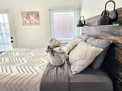 a bedroom with a bed with a wooden headboard at Eagle's Nest - Hot Tub & Stunning Bay View - Walk To Little Italy in San Diego