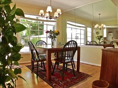 a dining room table with four chairs and a mirror at Sunny Gardens A Classic La Jolla Beach Home Close to Wind n Sea Beach in San Diego