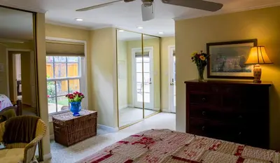 a bedroom with a bed and a dresser with a mirror at Sunny Gardens A Classic La Jolla Beach Home Close to Wind n Sea Beach in San Diego