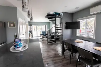 a living room with a dining room table and a staircase at Sunrise Loft in San Diego