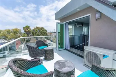 a balcony with wicker chairs and tables on a building at Sunrise Loft in San Diego