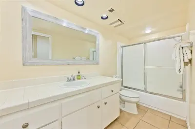 a bathroom with a sink and a toilet and a mirror at Seas the Fun in Newport Beach
