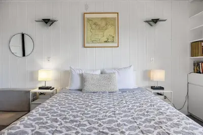 a bedroom with a bed with two lamps and a map at Shoreline Hideaway in San Diego