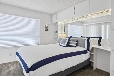 a bedroom with a large bed with blue and white pillows at Shoreline Hideaway in San Diego