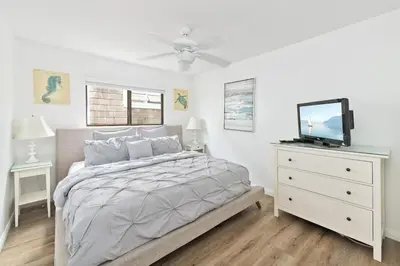 a bedroom with a bed and a tv on a dresser at Spacious Oceanfront Home Near Newport Pier in Newport Beach